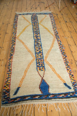 Plush ivory pile texture, colorful speckled border, and fringe of vintage Moroccan rug.