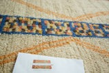 Plush ivory Moroccan runner pile, geometric lattice motif in blue, saffron, and burnt orange.