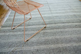 Textured vintage flatweave showing speckled ground and varying beige and silver striped bands.