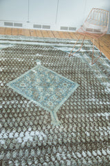Textured charcoal field with distressed patches and a sky blue herati medallion.