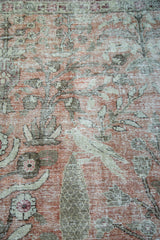 Distressed vintage Tabriz carpet pile, blush red and green tree motifs, exposed foundation.