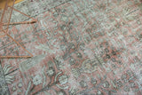 Distressed blush red pile of vintage Tabriz carpet with exposed foundation.