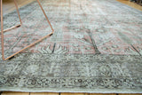 Vintage Tabriz carpet detail: distressed blush red field and earthen green patterned border.