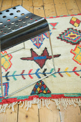 Vibrant geometric motifs and plush pile texture on vintage Moroccan rug, with fringe.