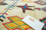 Plush pile of a vintage Moroccan rug with vibrant saffron yellow, red, and mint geometric patterns.