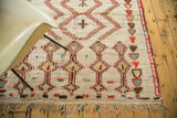 Fringed end of vintage Moroccan rug, plush pile with brick red and mint geometric motifs.