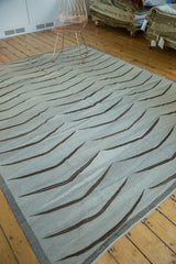 Modern hand woven grey Kilim detail, showing charcoal bowed mountain motifs and woven edge.