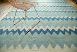 Repeating zigzag pattern and hand woven texture of the Egyptian kilim in blue, ivory, grey.
