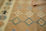 Hand woven vintage Kilim rug's geometric diamond motifs and border patterns in soft bronze, aqua, and ivory.