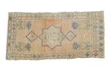 Vintage Oushak runner with faded peach central medallion, blue, green floral spandrels.