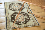 Secured side edge of vintage Oushak rug with charcoal brown and beige geometric pattern.
