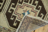 Textural close-up of vintage Oushak rug, showing geometric pattern, etched outlines, and hand-knotted back.