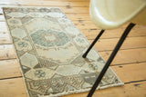 Faded vintage Oushak runner corner showing checkered design and hexagonal border in pastels.
