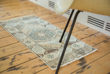 Oushak rug runner showing faded pastel tones, ornate medallion, and hexagonal motifs.