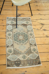 Lower corner of vintage Oushak runner, highlighting checkered design, hexagonal border, and fringe.