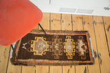 Hand-knotted pile showing geometric medallions and striped borders in brown, saffron yellow, and tangerine.