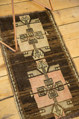 Blush square medallion with geometric arrow motifs on dark chocolate brown Oushak rug.