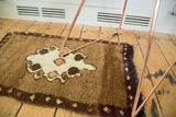 Plush brown pile, chocolate border, and faded tangerine diamond motifs on vintage Oushak rug.