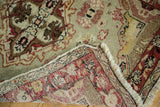 Distressed Oushak rug corner, revealing hand knotted foundation, ivory fringe, and muted pile.
