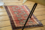 Vintage Oushak rug mat's cherry red field and repeating geometric floral motifs show pile wear.