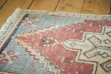 Vintage Oushak rug's fringed edge and stepped pattern in cinnabar red, ivory, and grey.