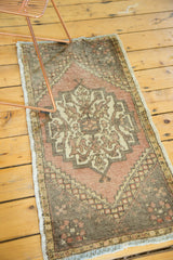 Vintage distressed Oushak rug featuring soft peach, ivory hexagonal medallion, and corner floral design.