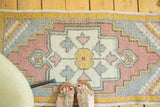 Vintage Oushak rug section with stepped medallion, diamond stylizations, ivory, grey, rose, yellow.