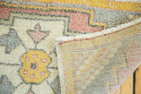 Vintage Oushak rug showing hand-knotted reverse, fringe, and pastel geometric corner motifs.