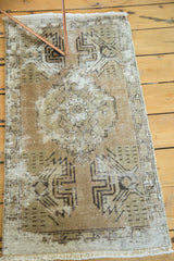 Faded germinating planter design and fringe on the distressed vintage Oushak rug corner.