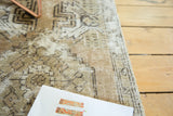 Distressed Oushak rug close-up, faded coffee, sand, and charcoal brown geometric pattern.
