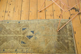 Vintage Oushak runner, faded bronze, green, and blue geometric patterns with even wear.