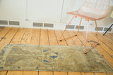 Corner view of the vintage Oushak runner, showing faded bronze, brown tones and even wear.