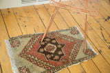 Vintage Oushak rug corner with fringe, displaying soft sea foam green and dark copper geometric patterns.