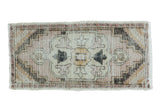 Vintage Oushak runner, stepped floral medallion in faded rose, gold, and charcoal, distressed.