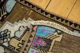 Rolled fringe and village weave detail of a vintage Oushak rug in brown and blue tones.