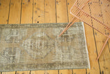 Distressed vintage Oushak rug corner with faded coffee brown and charcoal planter motif.