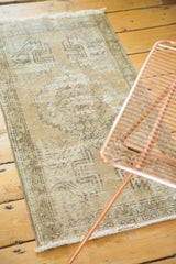Faded coffee brown and charcoal splayed floral motifs on a distressed Oushak rug.