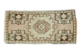 Vintage Oushak runner with ornate central medallion, germinating planters, pale sand blush, faded green, and brown.