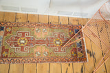 Geometric double medallions and star motifs in brick red, moss green on Oushak runner.