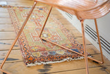 Vintage Oushak runner showing its brick red, tangerine geometric border and off-white fringe.