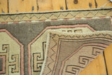 Vintage Oushak rug folded corner: hand-knotted pile, woven foundation, beige, blush geometric.