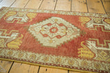 Stepped center medallion with splayed floral and planter motifs in brick red, ivory, saffron gold.