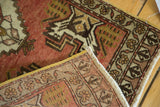 Hand-knotted Oushak rug revealing woven foundation and faded red, gold floral motifs.