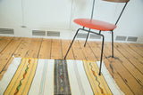 Fringed end of vintage hand woven Turkish Kilim runner with snow white and gold stripes.