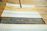 Hand-woven geometric patterns in gold, mint, and red on the Turkish Kilim runner.
