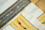 Hand-woven Kilim runner's geometric design with snow white, gold, charcoal, and mint green.