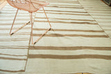 Hand-woven vintage kilim featuring varied linear ivory, bronze, coffee brown stripes, and construction seam.