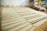 Ivory and bronze linear stripes on a hand woven Turkish Kilim rug, showing panel seams.