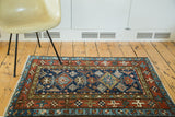 Vintage Karaja rug showing geometric star border in deep indigo and madder red.