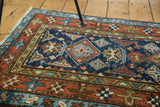 Geometric star border and expressive blue, red, and bronze motifs of a vintage Karaja rug.